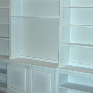 Custom built-in shelving system with open shelves and integrated lower storage in a living room