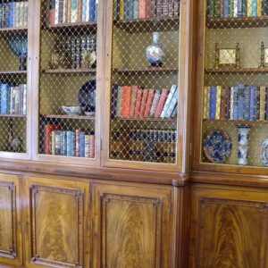 Classic glass-front built-in bookshelf with dark wood finish and integrated lower storage.