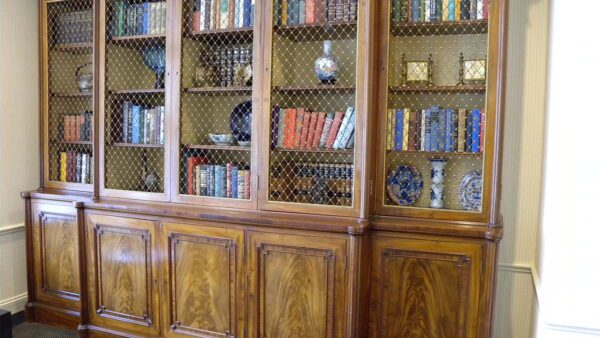 Classic glass-front built-in bookshelf with dark wood finish and integrated lower storage.