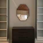 Built-in storage cabinetry with concealed cabinets and open shelving in a living room.