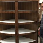 Curved corner storage cabinet with open shelving and natural wood finish.