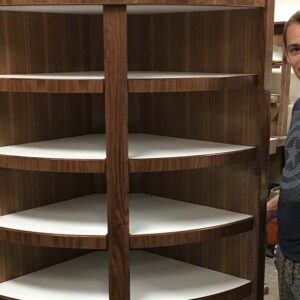 Curved corner storage cabinet with open shelving and natural wood finish.