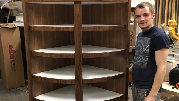 Curved corner storage cabinet with open shelving and natural wood finish.