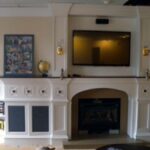 Handcrafted entertainment center with integrated library and fireplace surround.