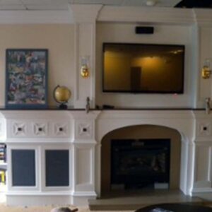 Handcrafted entertainment center with integrated library and fireplace surround.