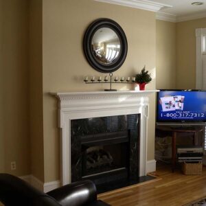 Handcrafted classic fireplace surround with painted architectural detailing.
