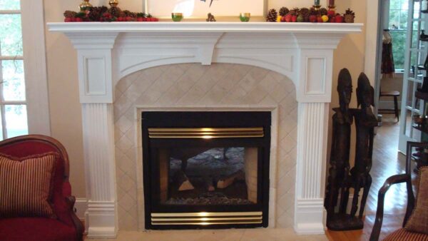 Handcrafted decorative fireplace surround with classic columns and arched mantel.