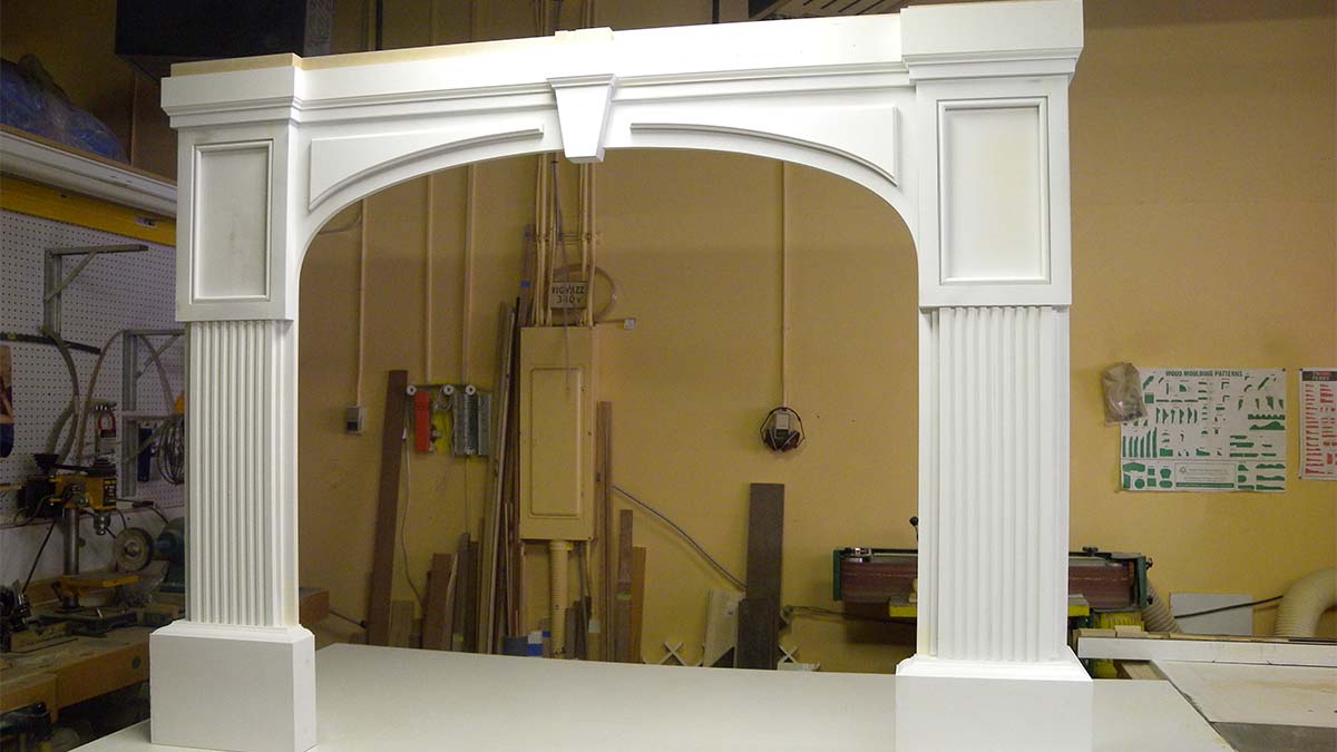 Classic architectural wood frame with arched opening and painted finish.