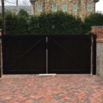 Custom wooden exterior gate with symmetrical design and dark wood finish.