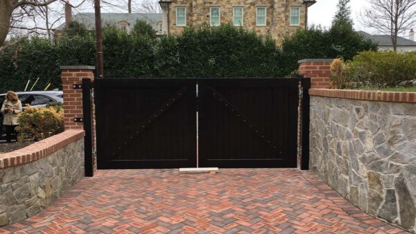 Custom wooden exterior gate with symmetrical design and dark wood finish.