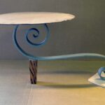 Handcrafted sculptural accent table with a freestanding configuration, organic flowing base, and minimalist tabletop designed for a modern living room.