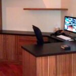 Handcrafted built-in office desk with natural wood finish, integrated cabinetry, and wraparound work surface designed for a modern workspace.