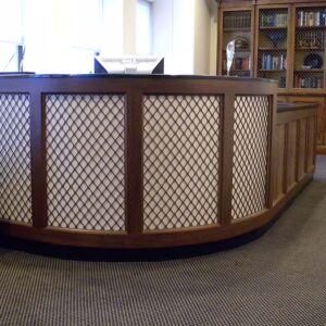 Handcrafted curved reception desk with solid wood construction, built-in configuration, and integrated front counter designed for a professional reception area.
